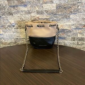 Melie Bianco two tone black and tan quilted bag with a gold chain strap.